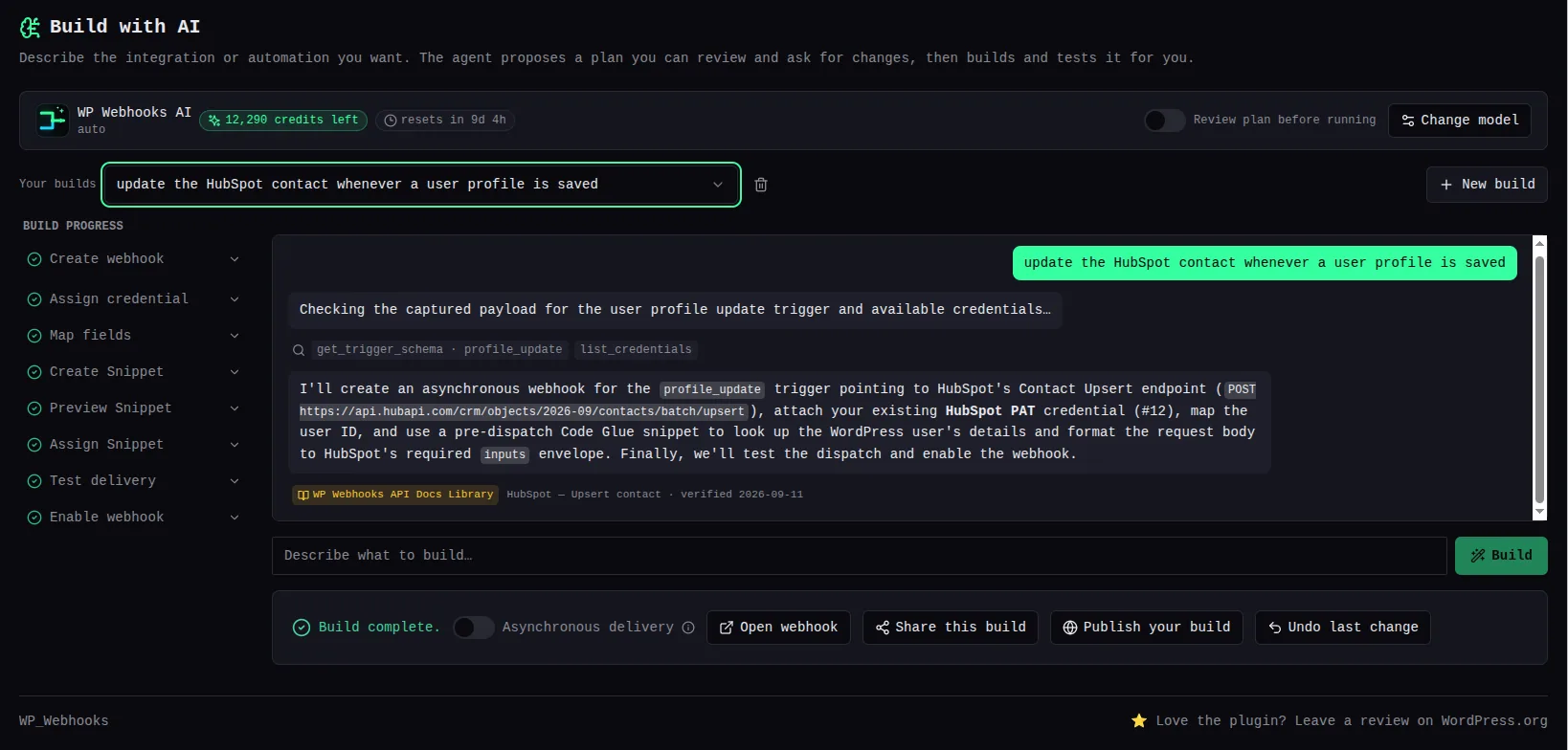 Build with AI after the prompt “update the HubSpot contact whenever a user profile is saved”: the reply explains it will create an asynchronous webhook on profile_update pointing at HubSpot’s date-versioned batch upsert endpoint, attach the existing HubSpot PAT credential and add a Code Glue snippet. Under the reply sits a small amber “WP Webhooks API Docs Library” pill reading “HubSpot — Upsert contact · verified 2026-09-11”, and the build progress list on the left shows every step complete.